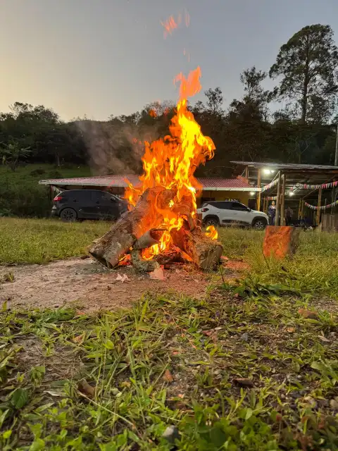 Fogata encendida al atardecer frente a la casa de la finca