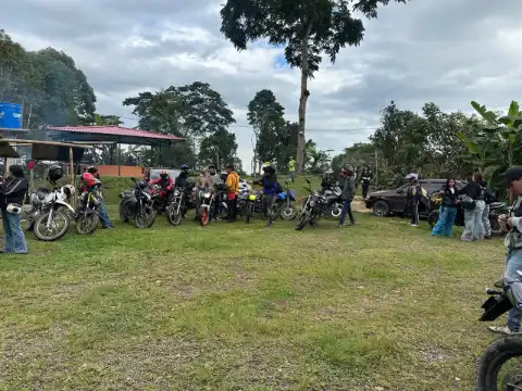 Grupo de visitantes con motos en el prado de la finca